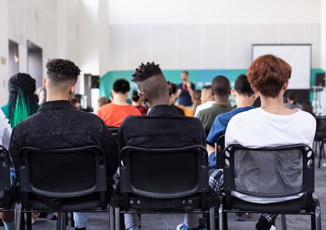 Präsenzunterricht: Gruppe von Teilnehmern im Sprachkurs mit Lehrer